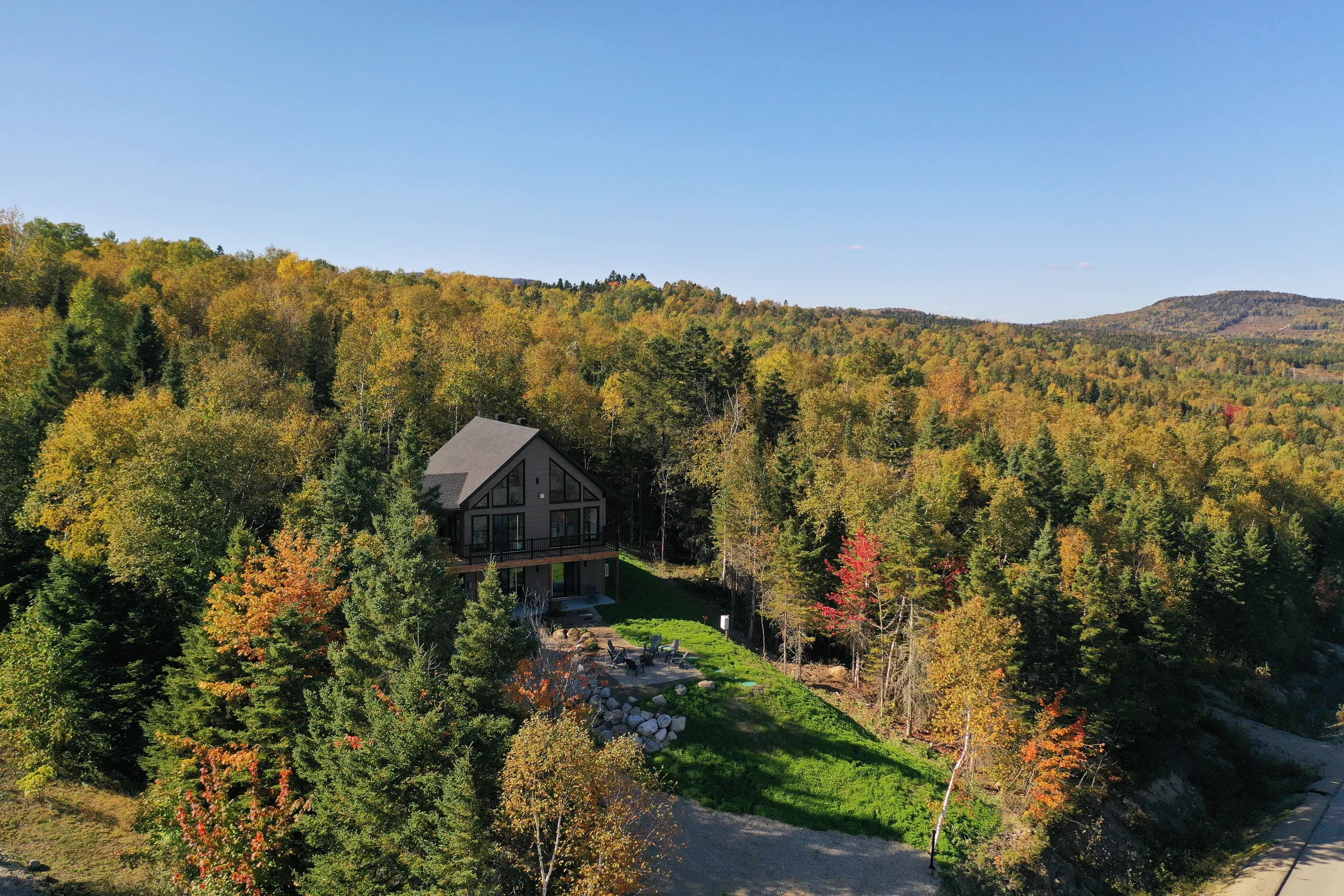 Aerial view of the KLIMA chalet surrounded by Charlevoix forest in fall colours